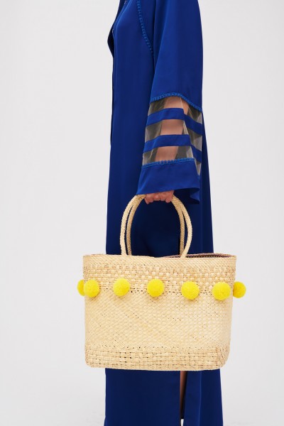 Straw bag with yellow pompoms